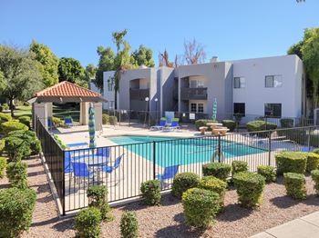 A house with a swimming pool and a patio with chairs